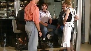 A sexy German lady gets fucked and pissed on at the bar by three hard cocks